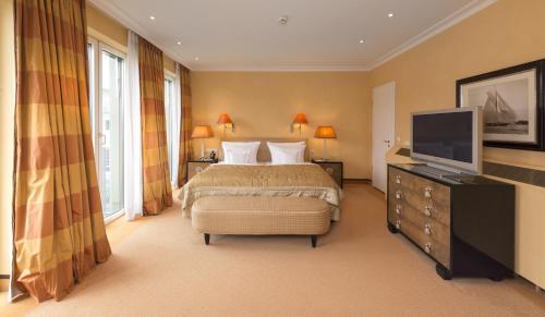 a bedroom with a bed and a flat screen tv at Parkhotel Bremen – ein Mitglied der Hommage Luxury Hotels Collection in Bremen