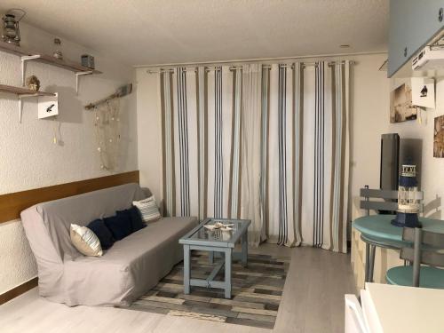 a living room with a couch and a table at Agréable studio Barcares in Le Barcarès
