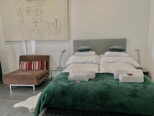 a bedroom with a bed with a green blanket at Dimora Apartman in Debrecen