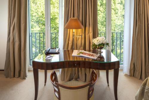 a desk with a lamp in a room with windows at Parkhotel Bremen – ein Mitglied der Hommage Luxury Hotels Collection in Bremen