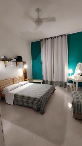 Un dormitorio con una cama grande y una pared verde. en Via Arriano 11, en Roma