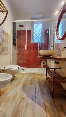 Un baño con dos lavabos y una ducha de cristal. en Via Arriano 11, en Roma