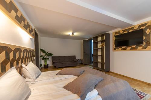 a bedroom with a large bed and a flat screen tv at Ranger Chalet in Moieciu de Sus