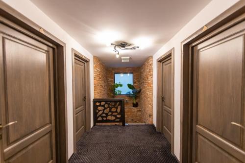 a hallway with two doors and a brick wall at Ranger Chalet in Moieciu de Sus