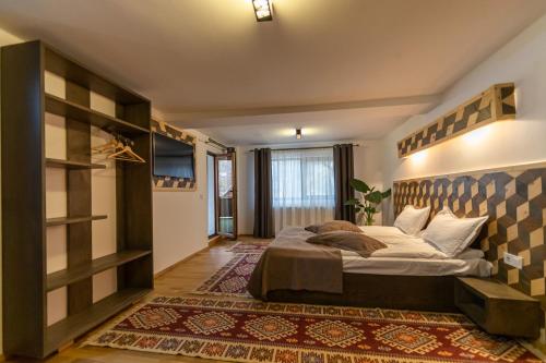 a bedroom with a large bed in a room at Ranger Chalet in Moieciu de Sus