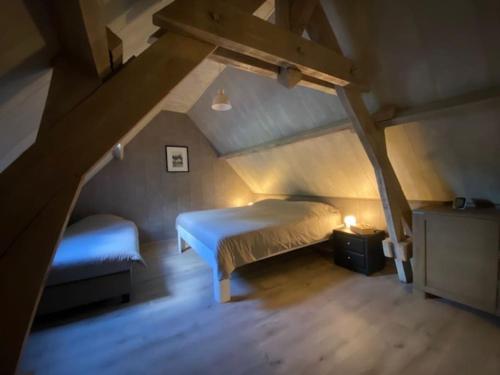 a bedroom with a bed and a bench in a attic at Cosy landelijk huisje nabij riviertje in Tertry