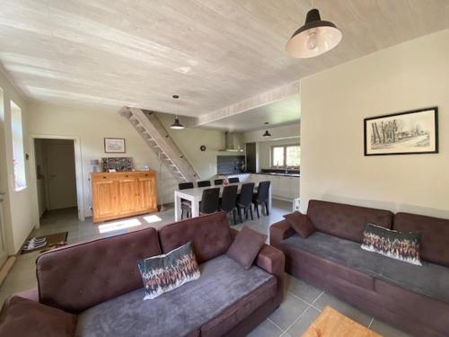 un salon avec deux canapés et une cuisine dans l'établissement Cosy landelijk huisje nabij riviertje, à Tertry