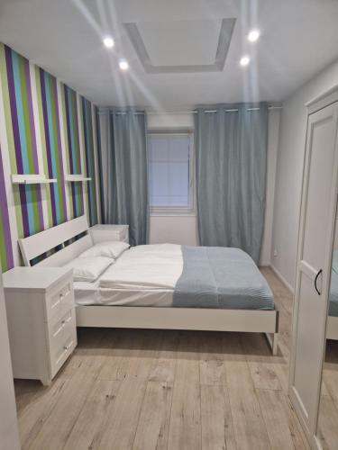 1 dormitorio con cama blanca y ventana en Apartament Turkusowy, en Jelenia Góra