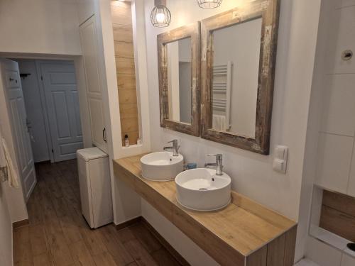 Baño con 2 lavabos y espejo en Apartament Turkusowy, en Jelenia Góra