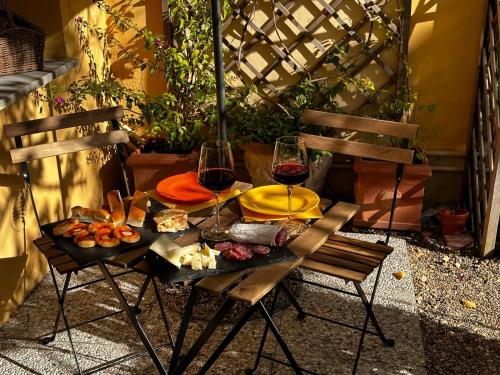 einen Tisch mit zwei Gläsern Wein und Essen drauf in der Unterkunft La Limonaia Firenze in Florenz