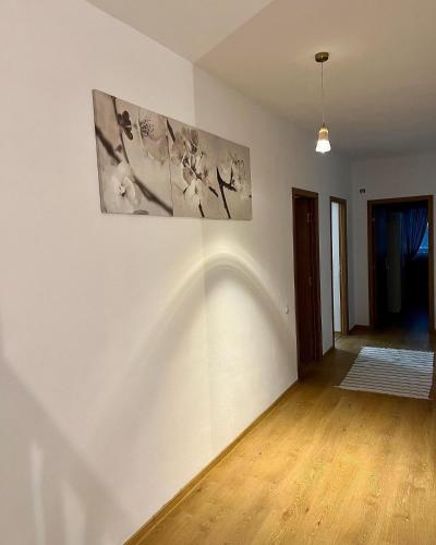a white room with two paintings on the wall at Casuta de la Munte in Sfodea