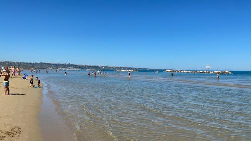 a group of people standing on a beach at Bellavista in San Salvo