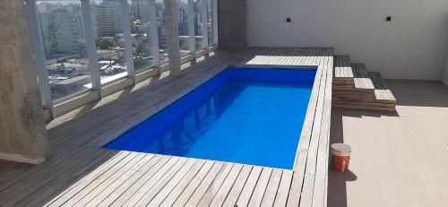 a blue swimming pool on a balcony of a building at Departamento Solares - San Martin in Bahía Blanca