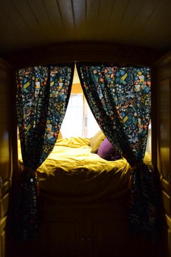 a bedroom with a bed with curtains and a window at Coeur de Vignes in Saint-Péray