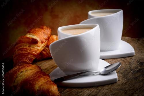 twee kopjes koffie en croissants op een tafel bij Suite SAN GENNARO in Napels