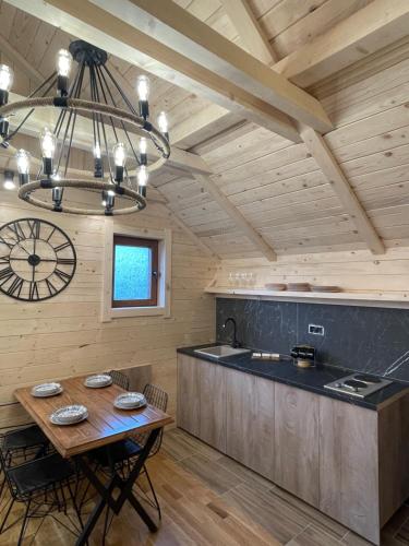 eine Küche mit einem Tisch und einer Uhr an der Wand in der Unterkunft Chalet Montenegrina with jacuzzi in Kolašin