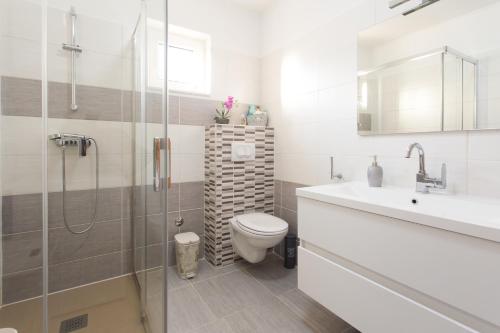 een badkamer met een toilet, een wastafel en een douche bij Villa Ivano with sea&mountain view in Kaštel Stari