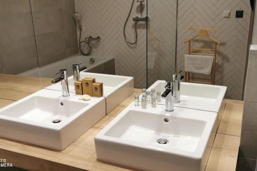 two white sinks in a bathroom with a mirror at Apartmán na Slnečných Jazerách v Senci in Senec