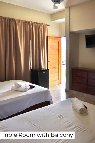 a hotel room with two beds and a window at Apartamentos En Edificio Amapola Zona Colonial Malecón in Santo Domingo