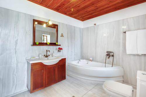 Un baño con bañera, lavabo e inodoro. en Traditional Home Vereniki With Heated Pool - BY APOKORONAS VILLAS, en Gavalochori