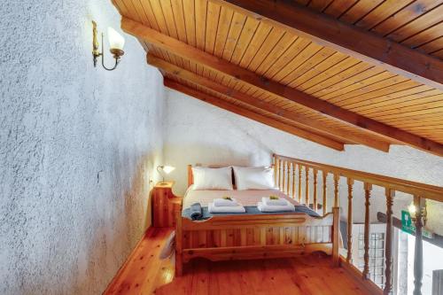 Un dormitorio con una cama y un techo de madera. en Traditional Home Vereniki With Heated Pool - BY APOKORONAS VILLAS, en Gavalochori