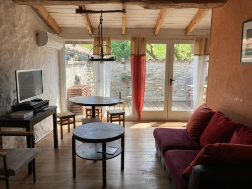 un salon avec un canapé et une table dans l'établissement Gîte Appartement dans maison de village, à Labeaume