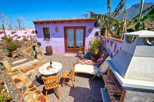 a backyard with a pink house with a table and chairs at Casitas Manuel in El Paso