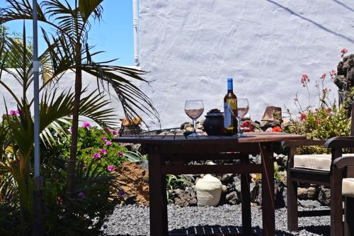 a table with two glasses and a bottle of wine at Casitas Manuel in El Paso