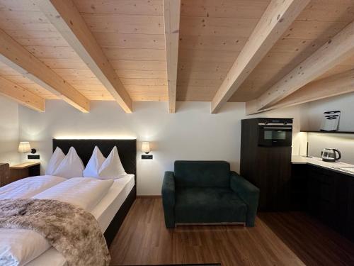 a hotel room with a bed and a chair at Pension Dorferwirt in Bramberg am Wildkogel