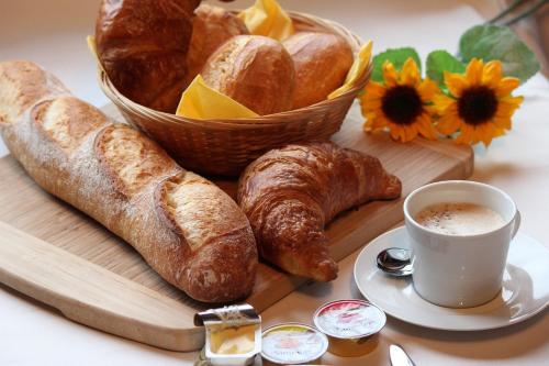 a tray of bread and croissants and a cup of coffee at Hallstatt Dachstein Inn in Gosau