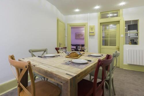 une table à manger avec des chaises et une table en bois avec des verres dans l'établissement Colmar Appt 4 pers centre ville 300m Petite Venise, à Colmar