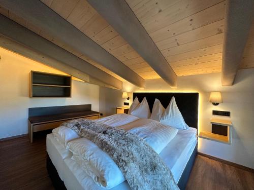 a bedroom with a large bed with a wooden ceiling at Pension Dorferwirt in Bramberg am Wildkogel