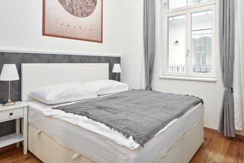 - une chambre blanche avec un lit et une fenêtre dans l'établissement Stylish Apartment in Smíchov by Prague Days, à Prague