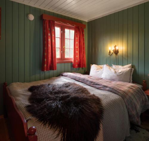 a bedroom with a bed with green walls and a window at Vestlia Ski in Geilo