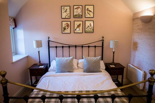 a bedroom with a bed with pillows and two lamps at Stylish bolthole in the heart of the Meon Valley in East Meon