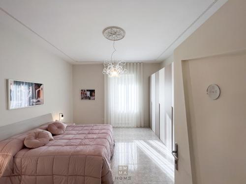 ein Schlafzimmer mit einem großen Bett und einem Kronleuchter in der Unterkunft Emma Home Matera in Matera