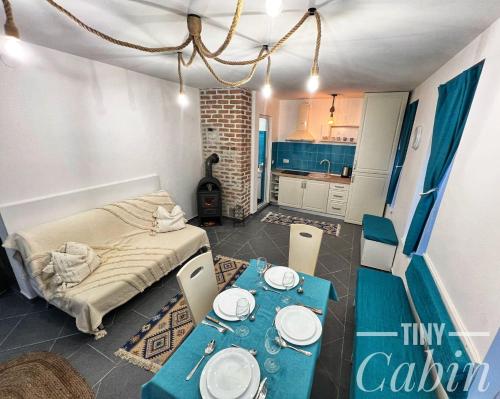 TINY CABIN في براشوف: غرفه بطاوله وسرير ومطبخ