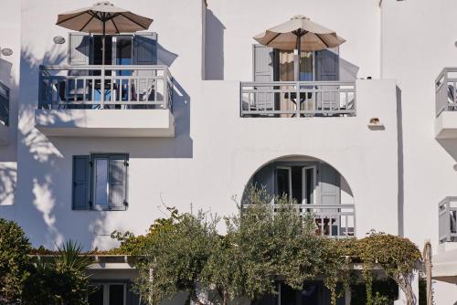a white building with two balconies with umbrellas at Kalergis Studios in Naxos Chora