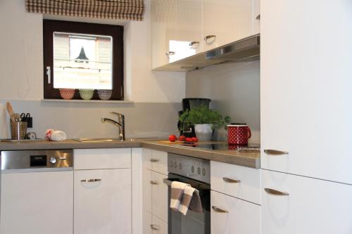 a kitchen with white cabinets and a sink at Gästehaus Rappenkopf in Oberstdorf