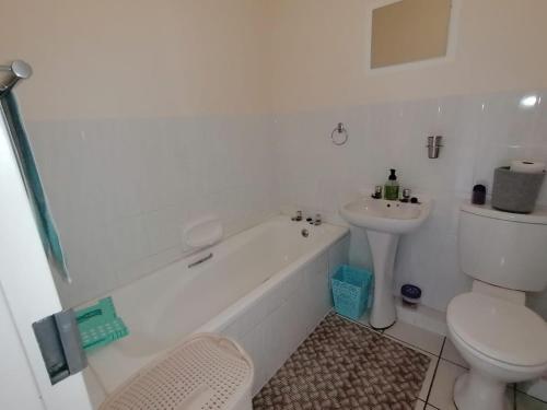 a bathroom with a tub and a toilet and a sink at 125 Laguna La Crete, Uvongo in Margate