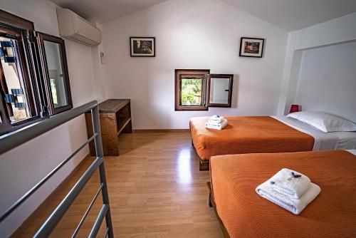 Habitación de hotel con 2 camas y ventana en Chara House en Skoutarion