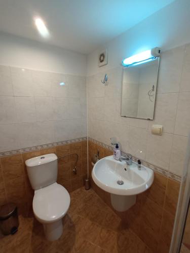 a bathroom with a white toilet and a sink at Guest rooms Bansko in Bansko