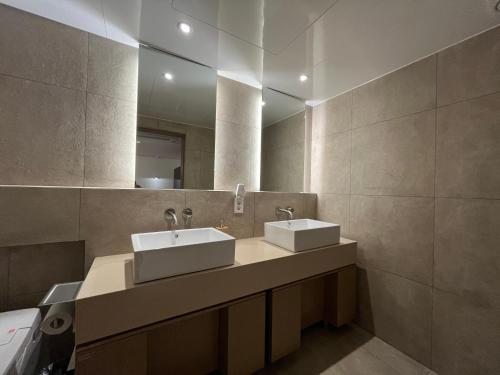 a bathroom with two sinks and a mirror at Sodo Hotel in Paju