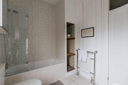 a bathroom with a shower and a bath tub at HIGH SAINT COTTAGE - Stunning 3 Bed Accommodation located in Ripon, North Yorkshire in Ripon