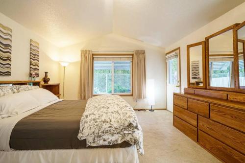 een slaapkamer met een bed, een dressoir en ramen bij Kozy Condo-Near PDX-EZFwyAccess-Fast Wi-Fi in Vancouver