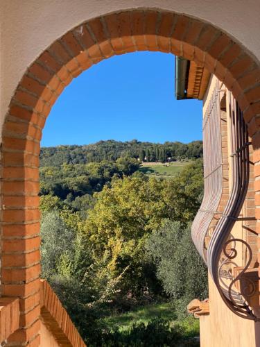 an archway of a building with a view of a field at Villa Cresci con piscina in Sassetta