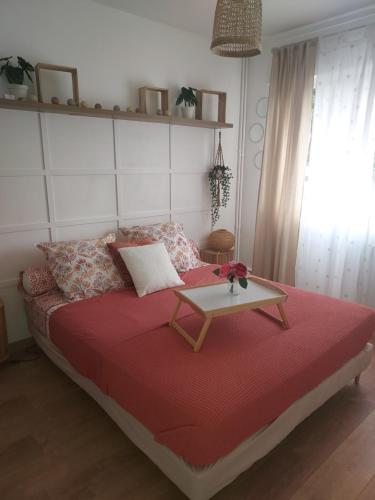 a bedroom with a bed with a table on it at Au Nid d'or : Appartement Tout confort Hyper Centre Béthune in Béthune