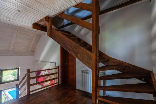 a wooden spiral staircase in a room with wood floors at Kežman Mountain Houses in Kopaonik