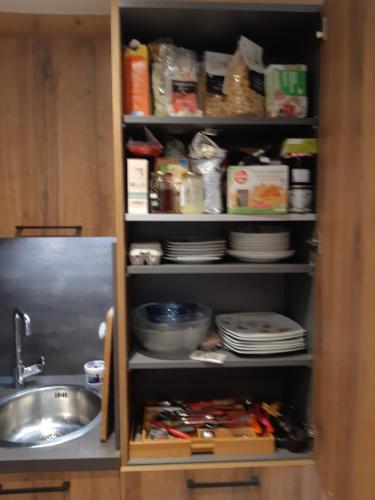 a kitchen pantry with a sink and a shelf with dishes at Le Soladret - 2 pièces 4 étoiles - Vue extraordinaire sur les Aravis in La Clusaz