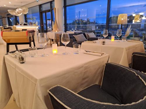 a dining room with two tables with wine glasses at Golden Tulip Porto-Vecchio in Porto-Vecchio